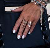 Adjustable irregular funky bar rings in silver, worn on a hand with white nails, showcasing their edgy designs.