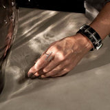 Adjustable irregular funky bar ring in silver-plated copper, worn on a hand alongside a chunky metal bracelet.