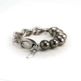 Thick silver-plated brass chain bracelet featuring gray shell pearls for a classy and trendy look.