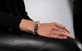 Shell pearl bracelet in silver tones with thick silver-plated brass chain, worn on a wrist, displaying a chic and modern look.