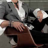 Shell pearl bracelet with thick silver-plated brass chain, worn on wrist, featuring shiny silver tones and chunky design.