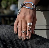 Two adjustable silver-plated rings connected by a stainless-steel chain with a horse bit, worn on a casual hand.