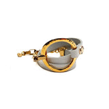 White leather triple wrap bracelet featuring a hammered gold loop and stainless steel chain, showcasing a bold, edgy design.