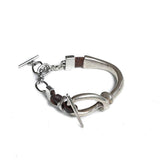 Silver-plated Zamak bracelet with adjustable brown leather, featuring a knot design and unique T-clasp closure.