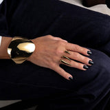 Adjustable double finger horns ring in 18K gold plated stainless steel, worn with black nails, paired with a bold gold cuff.