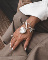 Textured heart charm bracelet in antique-plated silver, featuring a detailed heart pendant on a linked chain.