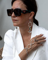 Stylish handmade stainless steel chain hand harness, connecting a ring to a bracelet, worn over a white blazer.