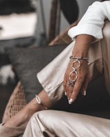 Handmade stainless steel chain hand harness featuring a ring connected to a wrist bracelet. Worn elegantly on the hand, with a sleek, edgy design.