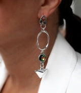 Long geometric dangle earrings featuring colorful Swarovski crystals, silver plating, and a modern design worn on the ear.