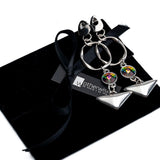 Colorful Swarovski crystal geometric dangle earrings with silver plated accents, presented on a sleek black pouch.