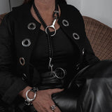 Chunky silver cuff bracelet featuring a large hoop and horse bit design, paired with genuine black leather.