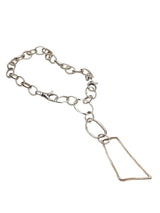 Asymmetrical silver plated statement necklace featuring large pendant with irregular loops, chunky carabiner clasp.