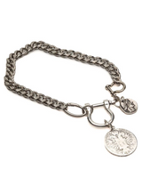 A silver-toned metal chain bracelet featuring a lobster clasp, a heart-shaped charm, and a round coin-style pendant with an engraved tree design, displayed on a clean white background.