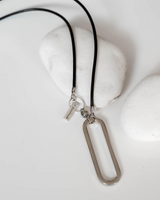 Necklace with a silver pendant on a white surface