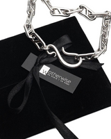 Silver chain necklace on a black velvet box with 'otherwise' brand tag.