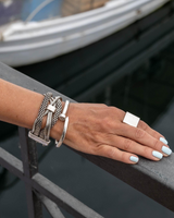 Chunky snake chains bracelet with multiple entwined silver chains, presented on a hand against a rail, showcasing an edgy look.