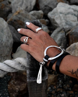 Bold wrap leather and metal cuff bracelet features multi-strand black leather and sculpted silver-plated hardware.