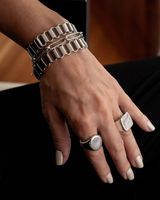 Layered chunky stainless steel bracelets with a unique hammered bangle, worn together on a model's wrist.