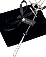 Silver necklace with a black bow on a black box, branded 'Otherwise'.