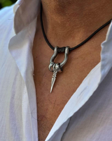 Silver pendant necklace on a person wearing a white shirt