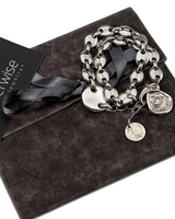 Silver chain bracelet with charms on a gray surface, accompanied by an Otherwise Jewelry card.