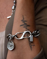 Silver bracelet with charms on a wrist, close-up