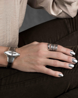 Funky hammered silver-plated metal ring worn on a hand with a metallic manicure, showcasing an edgy, adjustable design.
