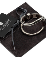 Silver ring on a dark gray velvet pillow with 'otherwise jewelry' tag.