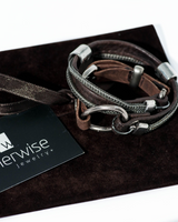 Bracelet with leather and metal straps on a black box with 'otherwise jewelry' card.
