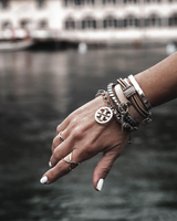 Silver-plated hammered bangle worn among other stacked bracelets on a model's wrist, showcasing a casual and edgy style.