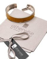 Striking yellow leather wrap bracelet with a bold buckle, accompanied by a silver-toned bangle.