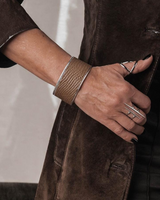 Close-up of a person wearing a brown suede coat with a blurred background