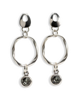 A pair of silver-toned dangle earrings with abstract oval links, teardrop-shaped posts, and round dark stone charms, shown on a plain white background.