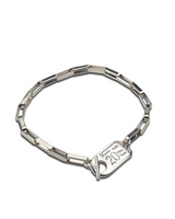 Silver bracelet with a heart-shaped clasp on a white background