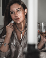 Woman holding a glass of wine behind bars