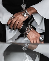 Close-up of hands wearing silver jewelry with a black and white background