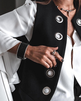 Person wearing a black and white outfit with circular buttons