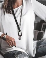 Person wearing a white top and ripped jeans sitting on a couch.