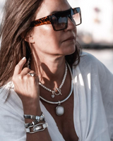 Three-piece Silver Lava Necklace Set worn by a woman, featuring a lava stone choker, silver-plated statement necklace, and adjustable bracelet.