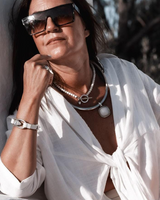Three-piece Silver Lava Necklace Set worn by a model. Includes a chunky choker with a crystal, a silver-plated statement necklace, and an adjustable bracelet. Model wears a white button-up shirt, showcasing the jewelry's layered style.