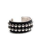 A wide black cuff bracelet featuring three horizontal rows of polished silver-tone round studs, photographed on a seamless white background.