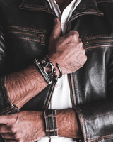 Person wearing a black leather jacket with visible jewelry on a neutral background