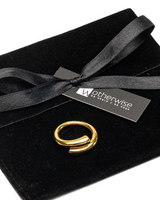 Gold ring on a black velvet box with a black ribbon and 'otherwise' label.