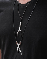 Person wearing a black t-shirt with a unique necklace featuring a deer head and antler design.