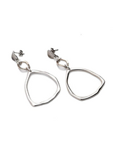 Hammered triangle dangle earrings in silver with a unique geometric shape and textured finish; 2.5 inches long.