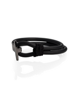 Black leather bracelet with metal clasp on a white background