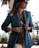 Woman wearing a blue blazer and sunglasses outdoors