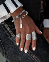 Hand wearing multiple silver rings with a blurred background