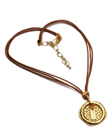 Natural leather strands necklace featuring a hammered gold metal hoop in an asymmetric design.