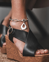 Stainless Steel Teardrop Anklet displayed on a foot with a black strappy wedge sandal, featuring a bold teardrop pendant.